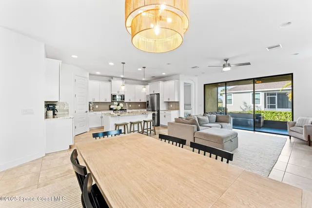 a living room with stainless steel appliances kitchen island granite countertop furniture and a large window
