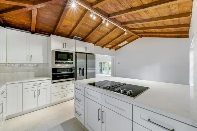 a kitchen with granite countertop a sink a stove and cabinets