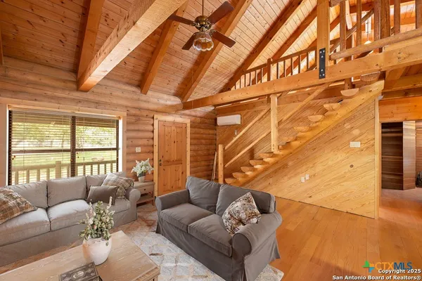 a living room with furniture a ceiling fan and a rug