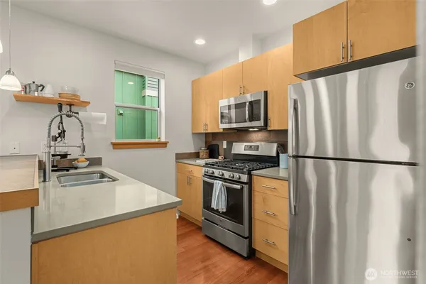 a kitchen with stainless steel appliances a refrigerator sink and stove