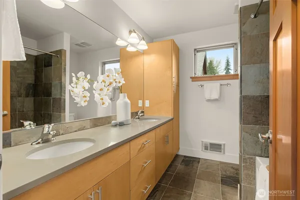 a bathroom with a granite countertop sink a mirror and a shower