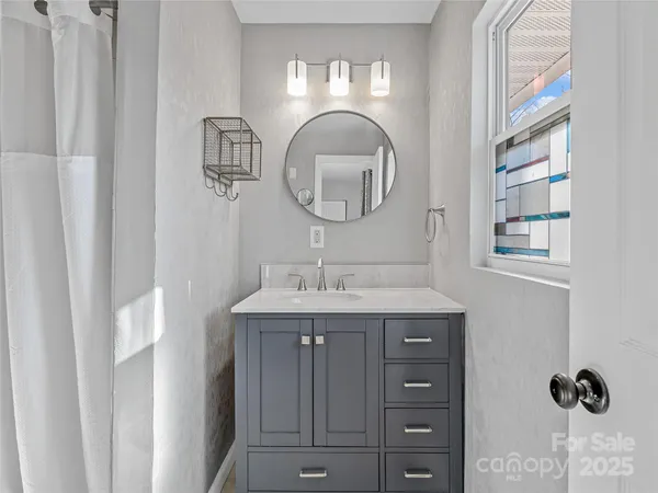 a bathroom with a granite countertop sink a mirror and a vanity