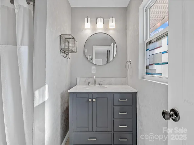 a bathroom with a granite countertop sink a mirror and a vanity