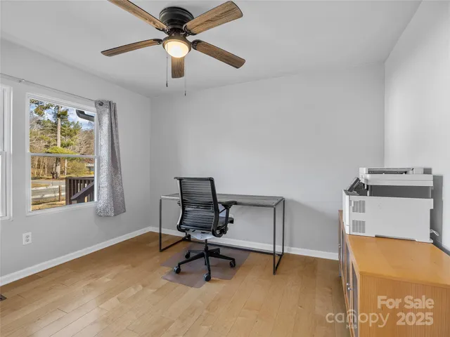 a view of a workspace with furniture and a window