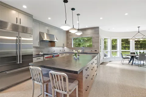 a dining room with furniture large windows and wooden floor