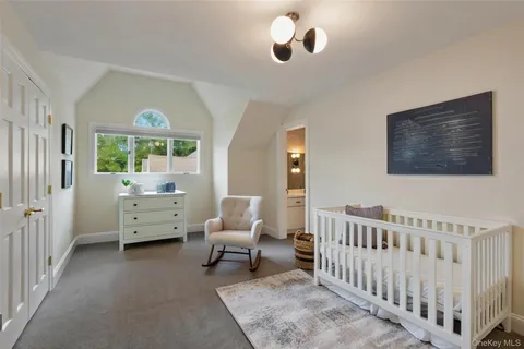 a bedroom with furniture and a large window