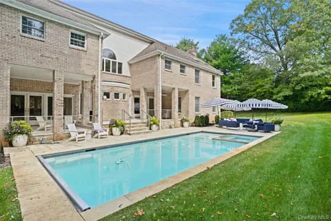a view of a swimming pool with lawn chairs under an umbrella