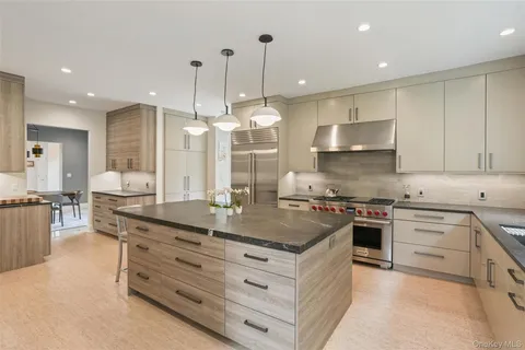 a kitchen with kitchen island a sink stainless steel appliances and cabinets