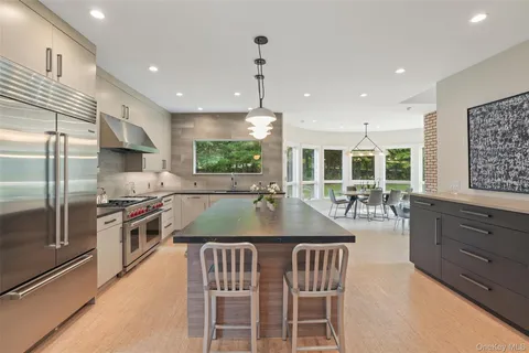 a kitchen with kitchen island a large counter top space appliances and windows