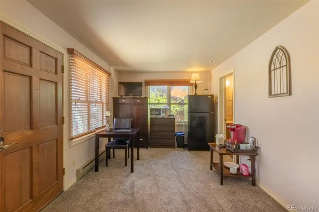 a bedroom with a bed and a dresser next to a window