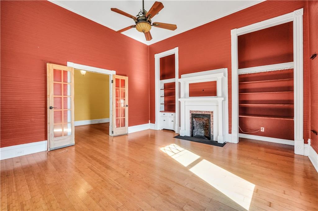 265 Kudzu Road Jenkinsburg, GA 30234 - Photo 12 of 38 a view of a livingroom with a fireplace a ceiling fan and wooden floor