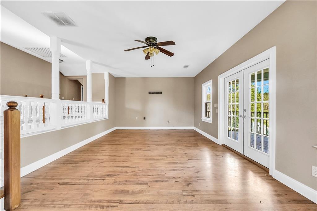 265 Kudzu Road Jenkinsburg, GA 30234 - Photo 27 of 38 a view of a big room with wooden floor a ceiling fan and windows