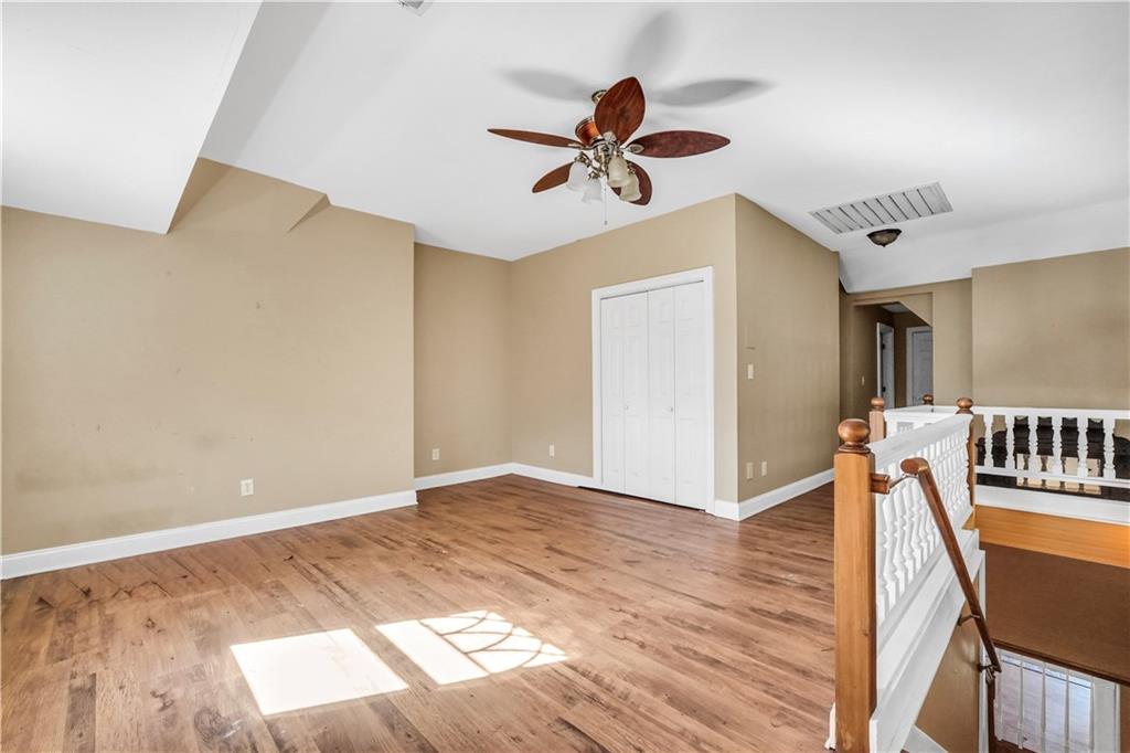 265 Kudzu Road Jenkinsburg, GA 30234 - Photo 29 of 38 a view of an empty room with wooden floor and a ceiling fan