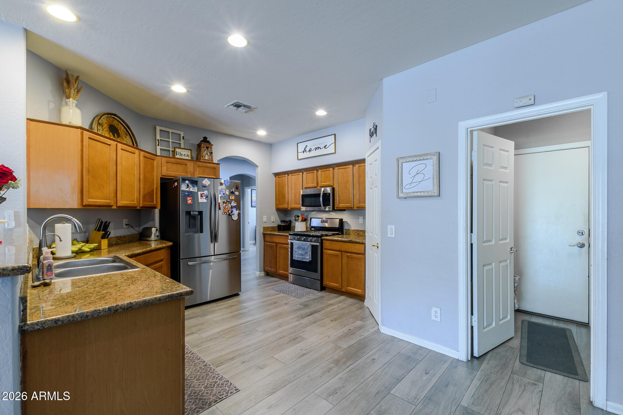 4521 West Moss Springs Road Anthem, AZ 85086 - Photo 15 of 35 a kitchen with stainless steel appliances granite countertop a refrigerator and a sink