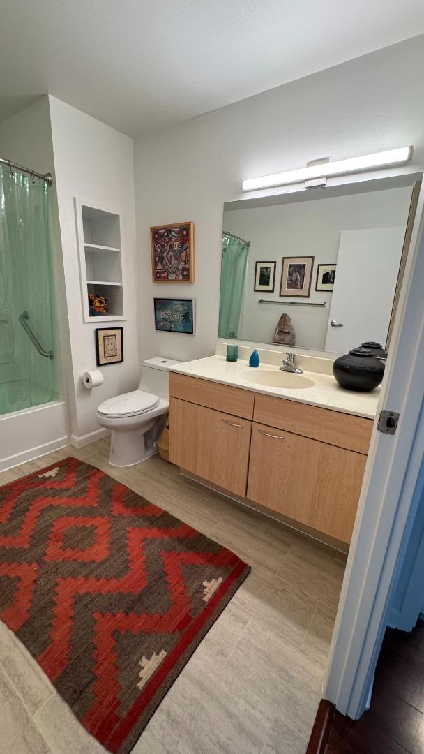 1 Lakeside Drive, Unit 602 Oakland, CA 94612 - Photo 18 of 26 a living room with stainless steel appliances furniture a rug and a window