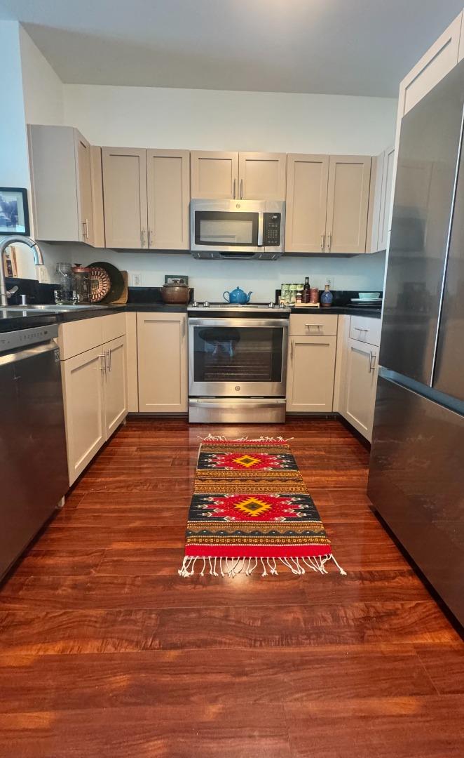 1 Lakeside Drive, Unit 602 Oakland, CA 94612 - Photo 3 of 26 a kitchen with granite countertop stainless steel appliances and wooden cabinets