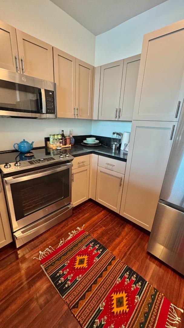 1 Lakeside Drive, Unit 602 Oakland, CA 94612 - Photo 4 of 26 a kitchen with stainless steel appliances granite countertop a stove microwave and sink