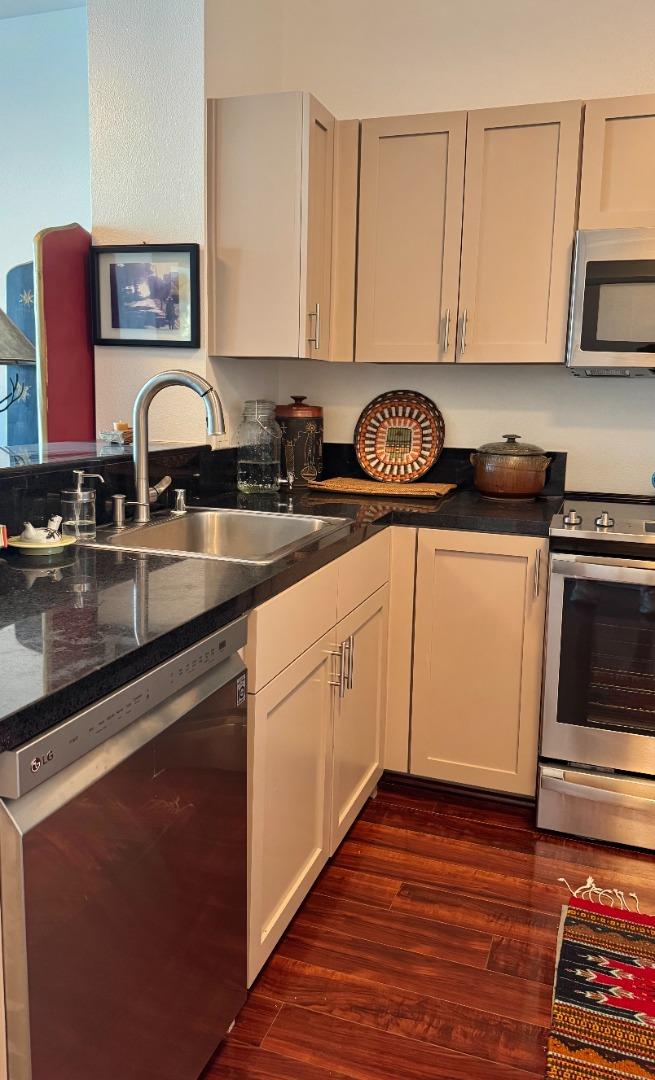 1 Lakeside Drive, Unit 602 Oakland, CA 94612 - Photo 5 of 26 a kitchen with stainless steel appliances granite countertop a stove a sink and a microwave