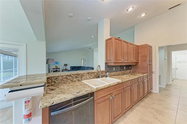 a large kitchen with stainless steel appliances granite countertop a stove top oven a sink and dishwasher