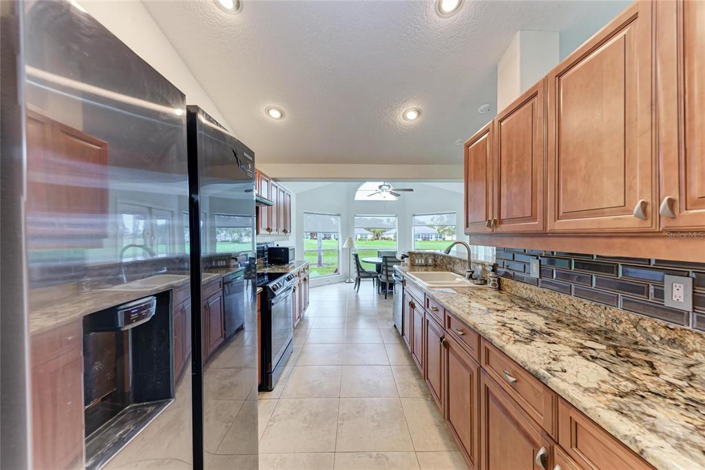 4906 Peridia Boulevard East Bradenton, FL 34203 - Photo 13 of 64 a large kitchen with stainless steel appliances granite countertop a stove top oven a sink and dishwasher