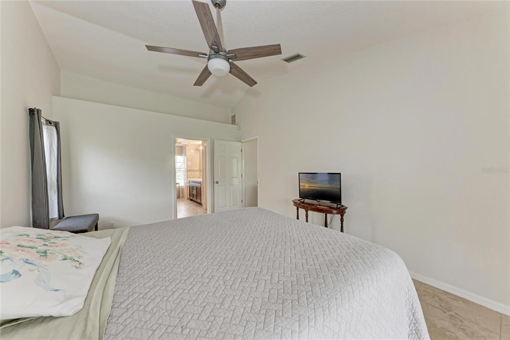 4906 Peridia Boulevard East Bradenton, FL 34203 - Photo 19 of 64 a bedroom with a bed and a chair