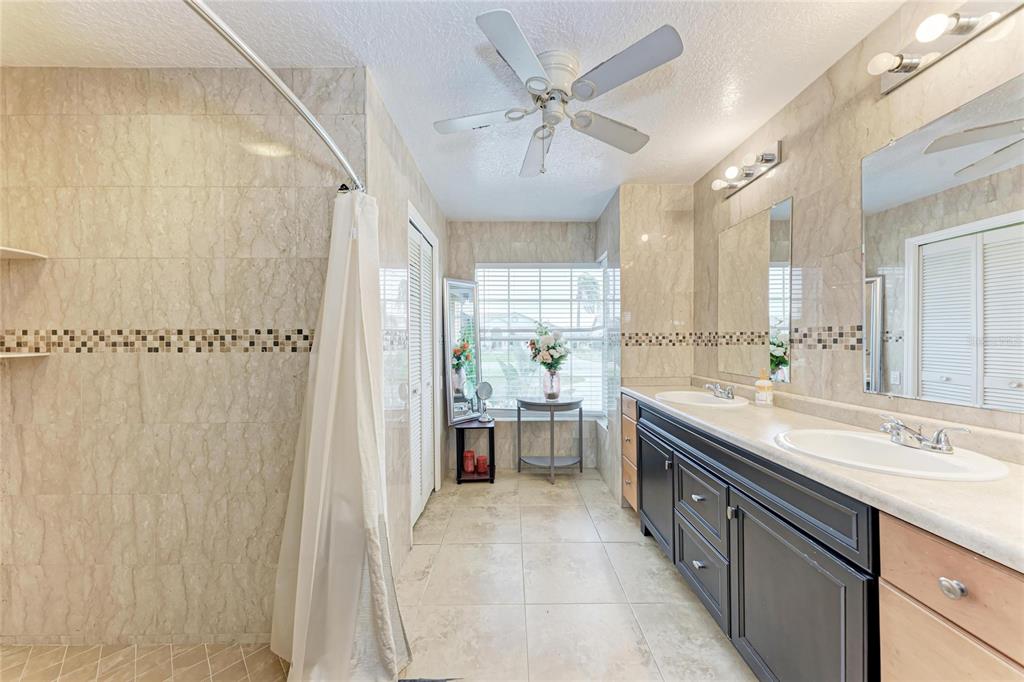 4906 Peridia Boulevard East Bradenton, FL 34203 - Photo 21 of 64 a large bathroom with a double vanity sink a mirror and a shower