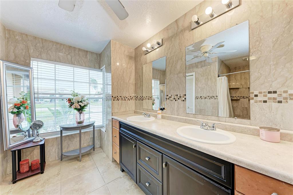4906 Peridia Boulevard East Bradenton, FL 34203 - Photo 22 of 64 a bathroom with a sink double vanity and a tub