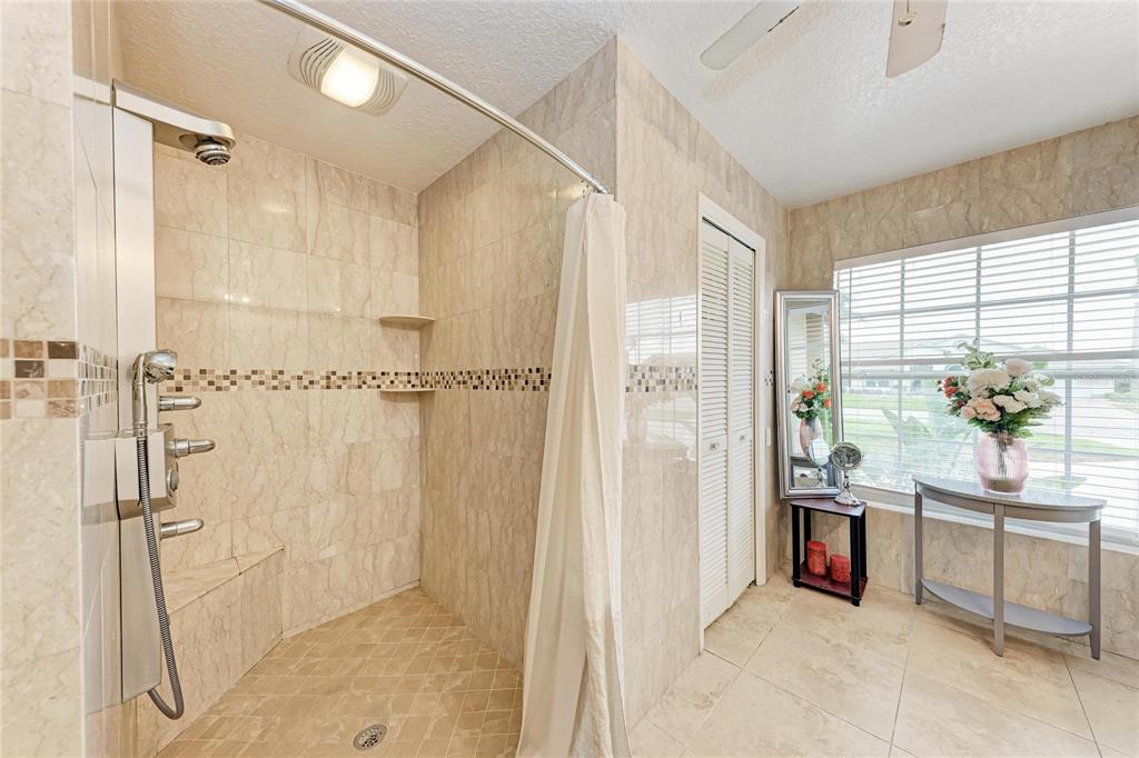 4906 Peridia Boulevard East Bradenton, FL 34203 - Photo 23 of 64 a spacious bathroom with a granite countertop sink a mirror and a shower