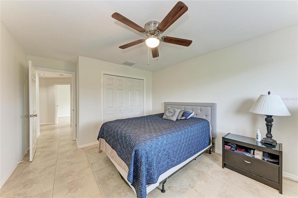 4906 Peridia Boulevard East Bradenton, FL 34203 - Photo 31 of 64 a bedroom with a bed and a ceiling fan