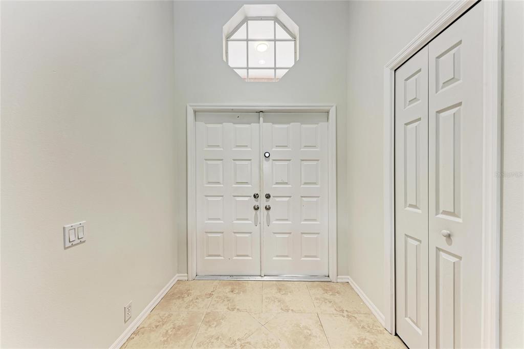 4906 Peridia Boulevard East Bradenton, FL 34203 - Photo 4 of 64 an empty room with wooden floor cabinet and window
