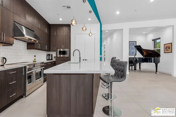 a kitchen with a stove a sink and wooden floor