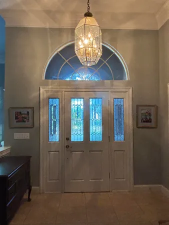 a room with chandelier and window