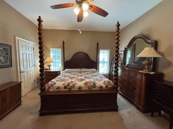 a bedroom with bed dresser and a chandelier