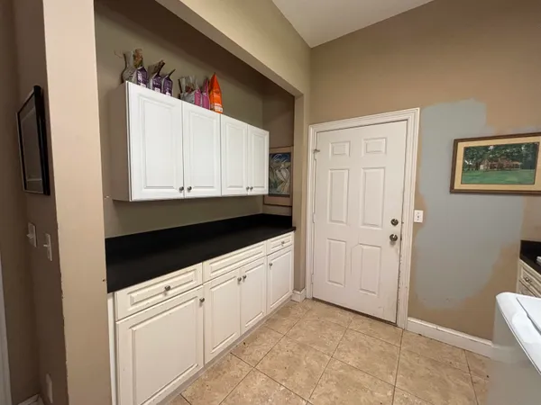 a kitchen with white cabinets and sink