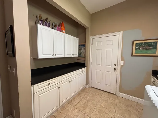 a kitchen with white cabinets and sink