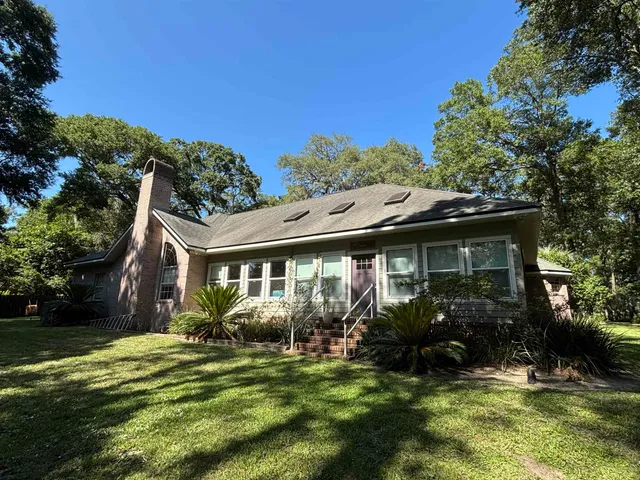 a view of a house with a yard patio and a garden