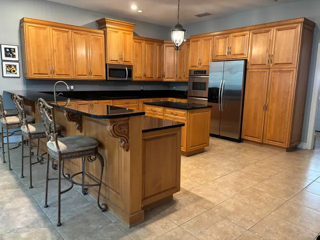 a kitchen with stainless steel appliances granite countertop a stove a sink and a refrigerator