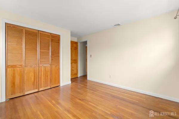 a view of an empty room with a window and a painting on the wall