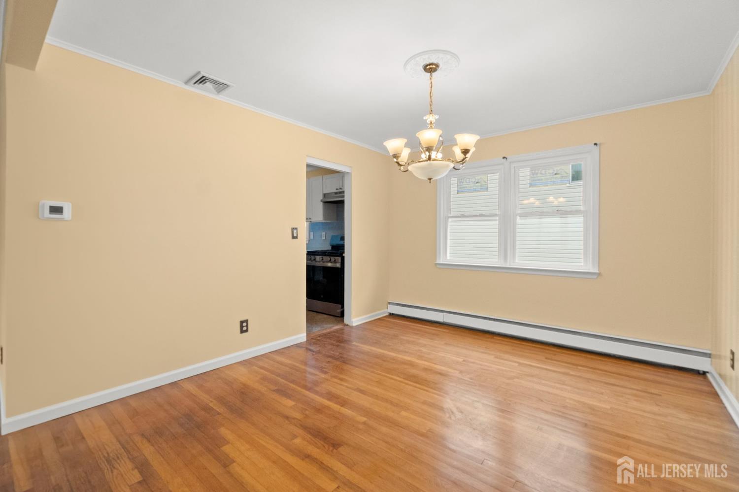 762 Valley Street Maplewood, NJ 07040 - Photo 6 of 21 a view of an empty room with chandelier and wooden floor