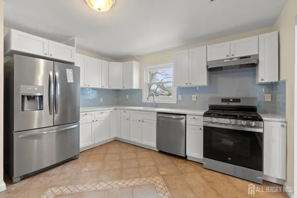 a kitchen with stainless steel appliances granite countertop a refrigerator sink and stove