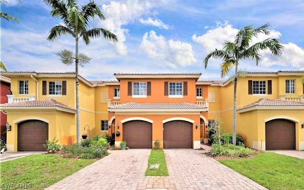 10190 Tin Maple Drive, Unit 130 Estero, FL 33928 - Photo 1 of 17 a front view of a house with a garden