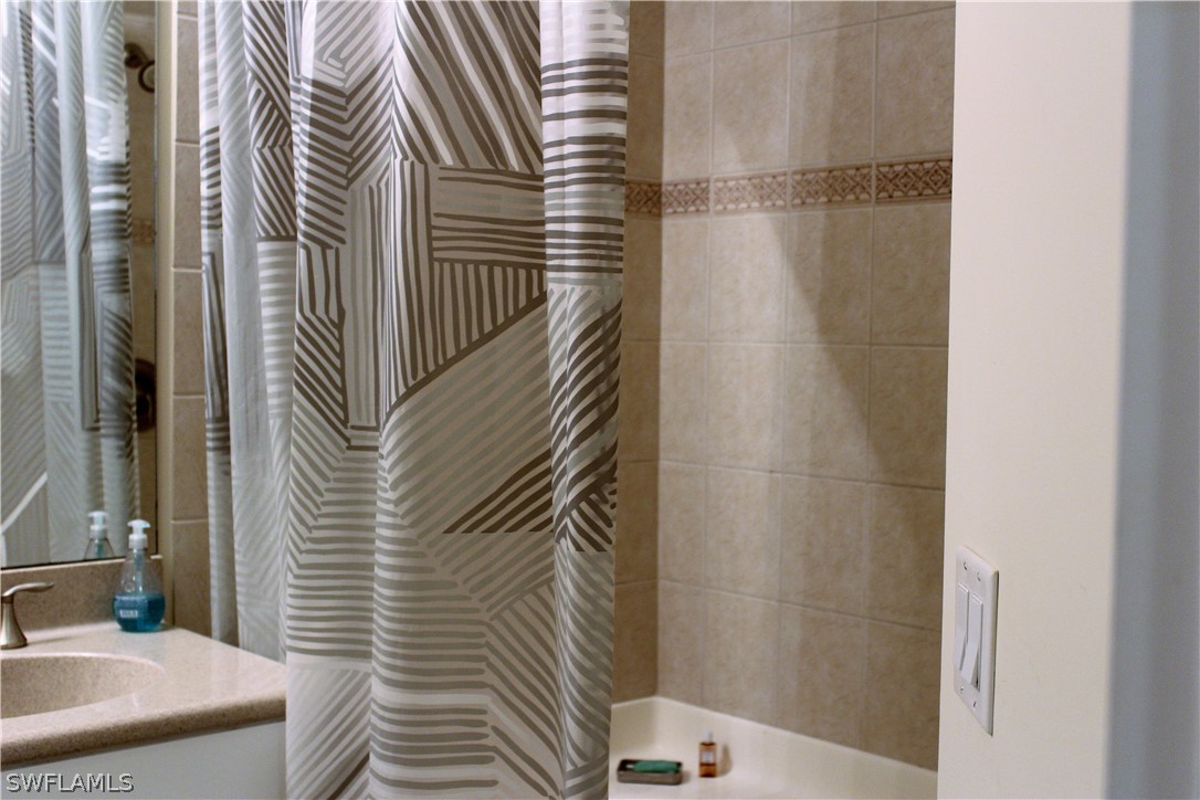 10190 Tin Maple Drive, Unit 130 Estero, FL 33928 - Photo 12 of 17 a bathroom with a sink and a mirror