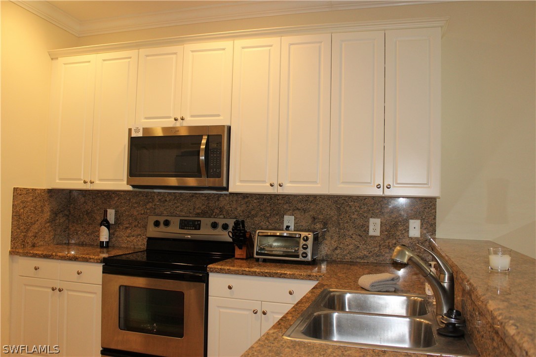 10190 Tin Maple Drive, Unit 130 Estero, FL 33928 - Photo 2 of 17 a kitchen with granite countertop a stove and a sink