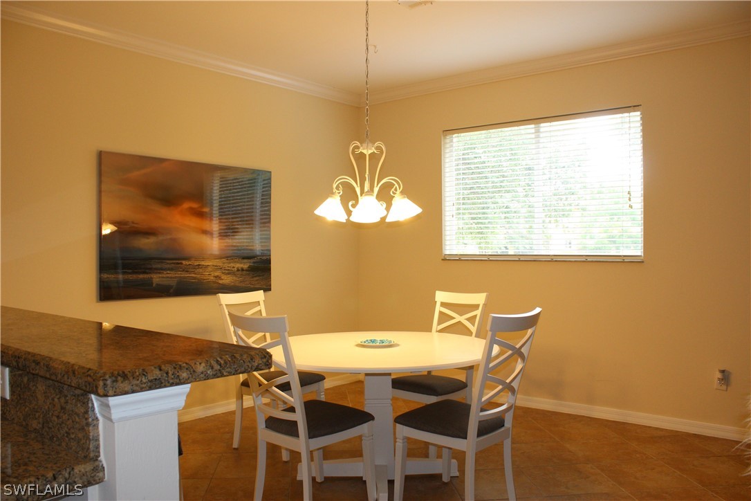 10190 Tin Maple Drive, Unit 130 Estero, FL 33928 - Photo 3 of 17 a view of a dining room with furniture and wooden floor