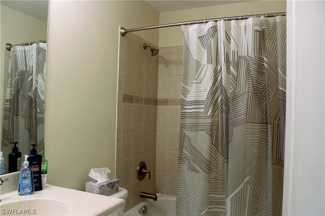 10190 Tin Maple Drive, Unit 130 Estero, FL 33928 - Photo 8 of 17 a bathroom with a shower curtain and a sink