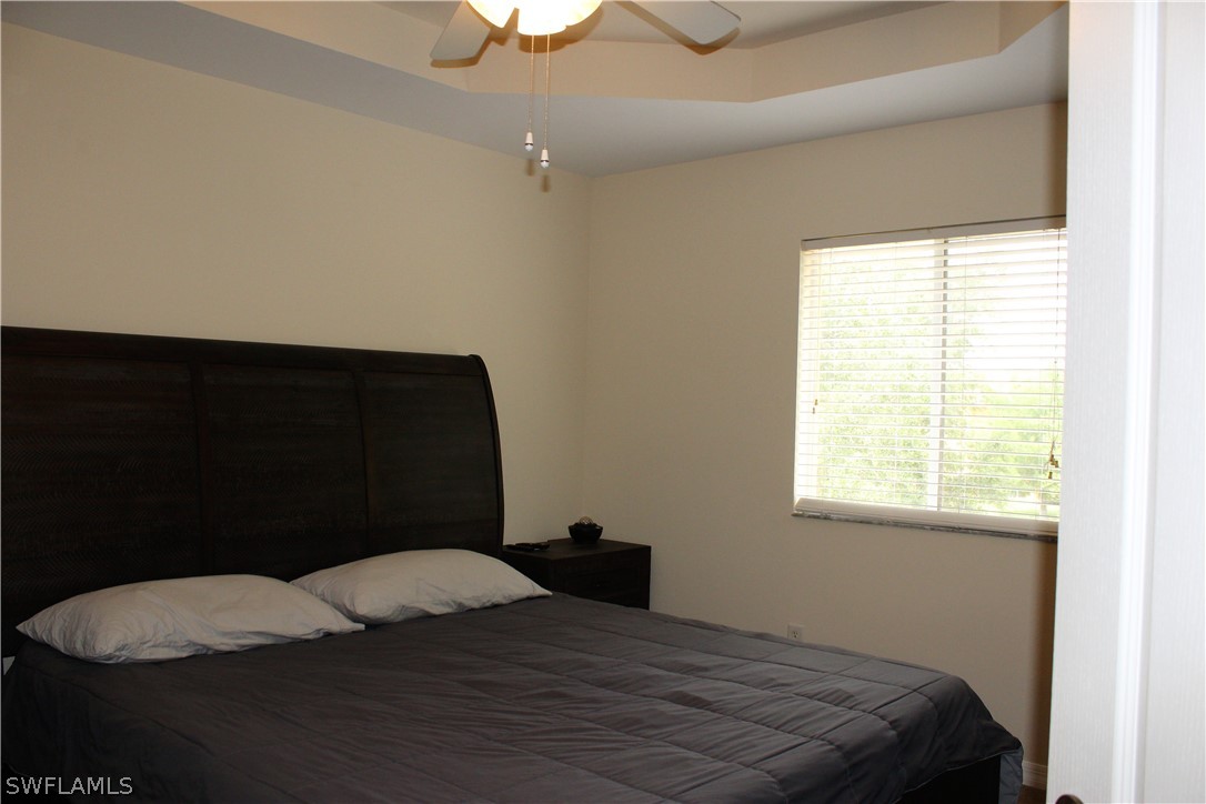 10190 Tin Maple Drive, Unit 130 Estero, FL 33928 - Photo 10 of 17 a bedroom with a bed dresser and a window