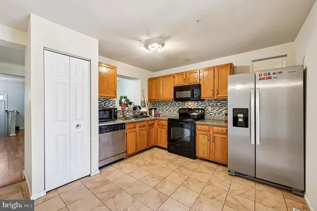 a kitchen with stainless steel appliances granite countertop a refrigerator and a stove top oven