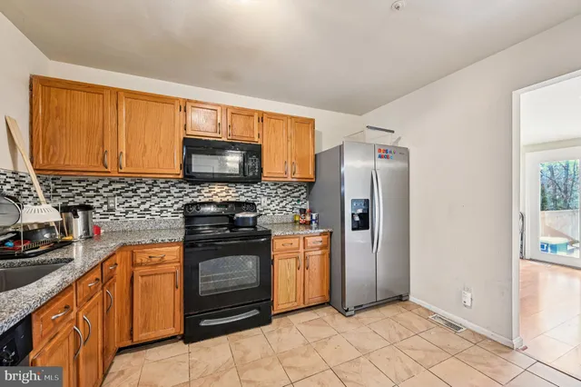a kitchen with stainless steel appliances granite countertop a refrigerator stove and sink