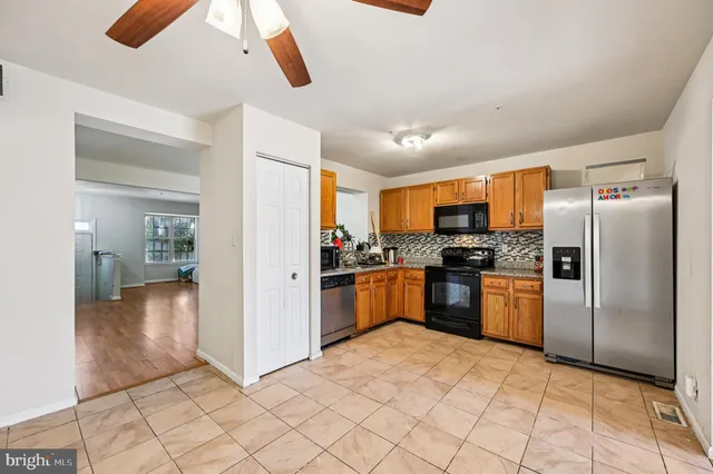a kitchen with stainless steel appliances granite countertop a refrigerator a stove top oven a sink and dishwasher