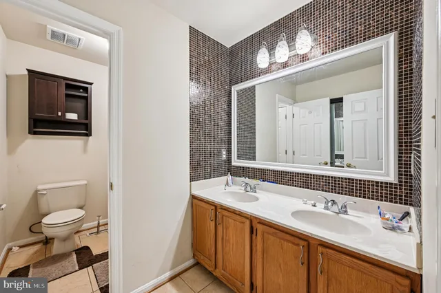 a bathroom with a double vanity sink a toilet and a mirror